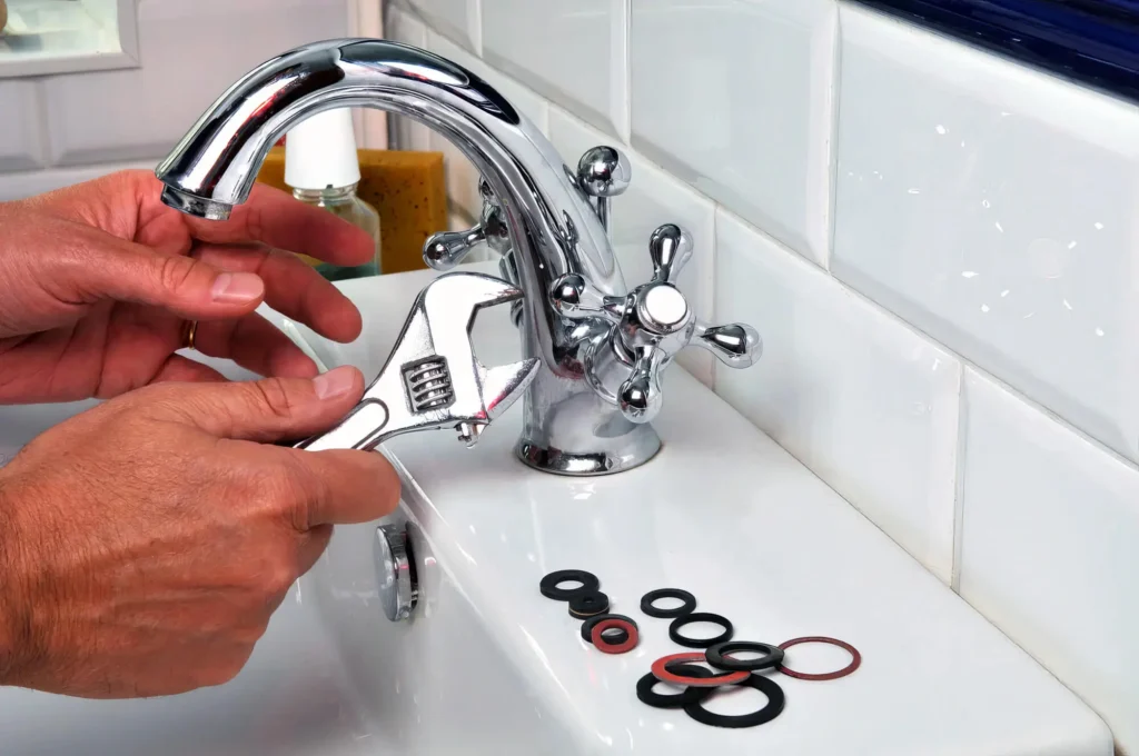 Plumber performing maintenance on a bathroom faucet in Holiday