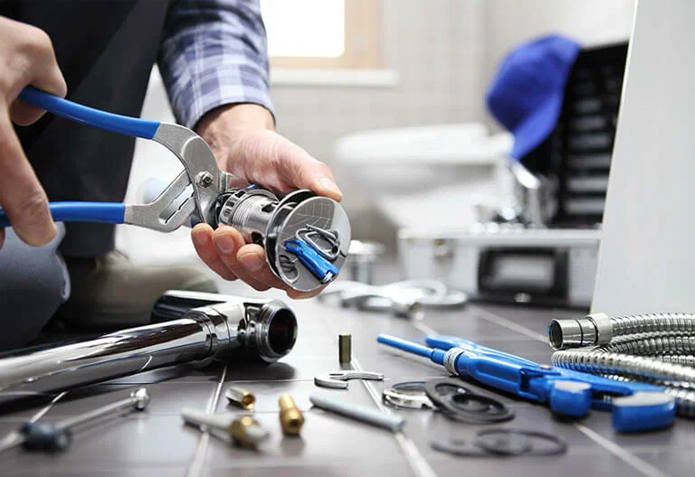 Technician repairing a plumbing fixture with professional tools in Holiday