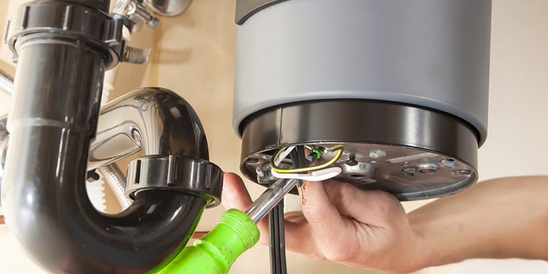 Technician repairing the heating element of a water heater in Holiday