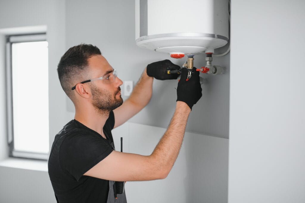 Technician performing water heater maintenance in Holiday