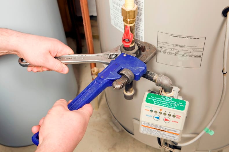 Plumber repairing a water heater valve in Holiday